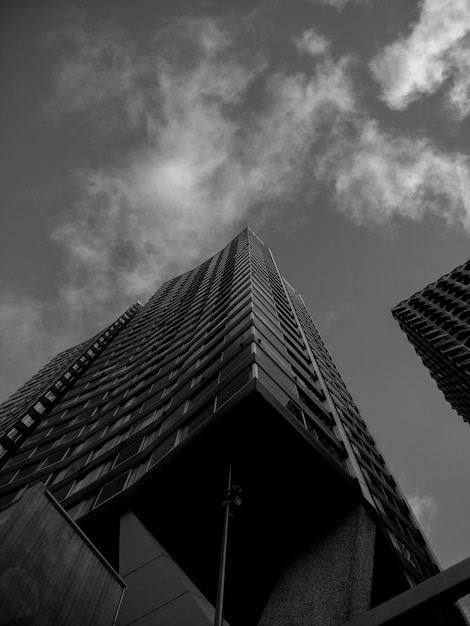 A modern high-rise building seen from below against a clouded sky
